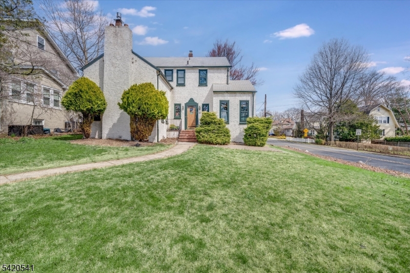 a front view of a house with a yard and potted plants