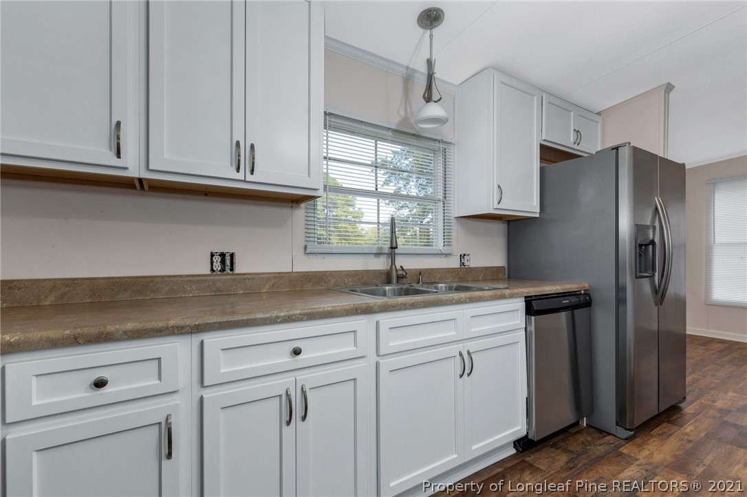 6544 Sandy Creek Road Stedman, NC 28391 - Photo 14 of 32 a kitchen with granite countertop white cabinets white stainless steel appliances and sink