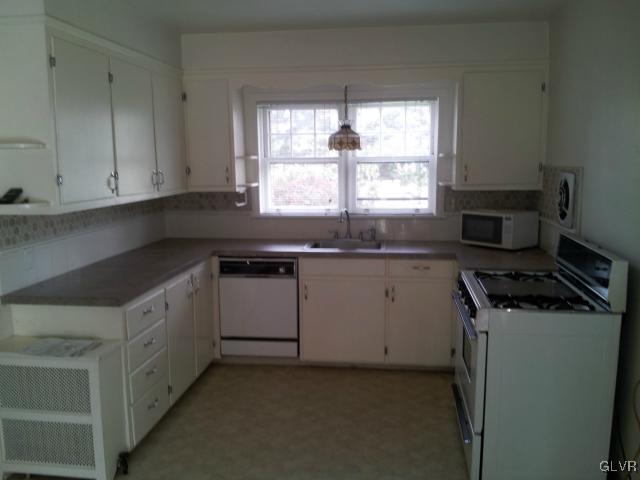 2110 Center Street Bethlehem, PA 18017 - Photo 4 of 12 a kitchen with granite countertop white cabinets and a stove top oven