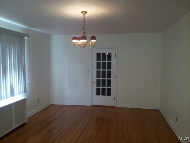 2110 Center Street Bethlehem, PA 18017 - Photo 6 of 12 an empty room with wooden floor chandelier and windows