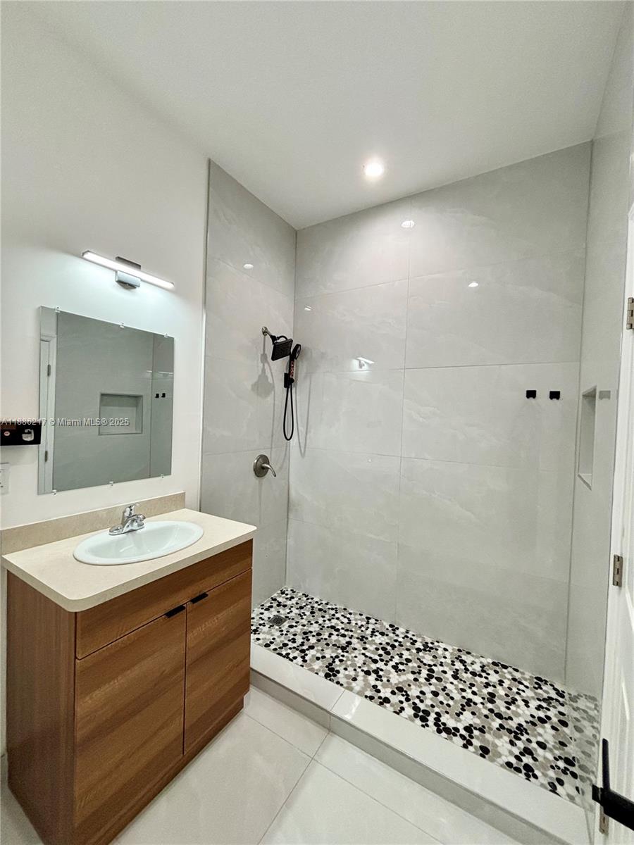 5737 Cleveland Street, Unit 2 Hollywood, FL 33021 - Photo 14 of 18 a bathroom with a sink a toilet a shower and a mirror