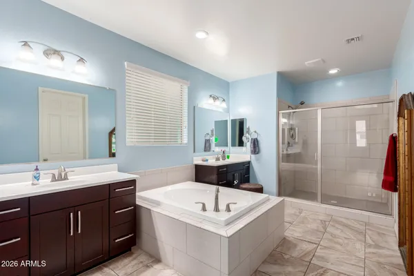 a spacious bathroom with a tub sink shower and mirror