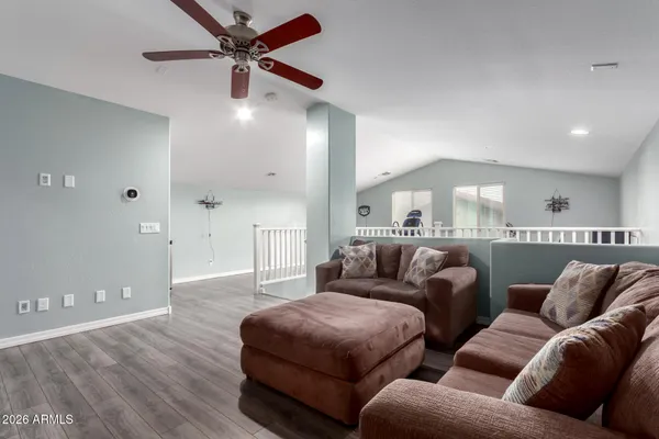 a living room with furniture and a ceiling fan