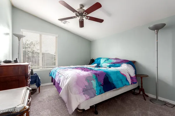 a bedroom with a bed a chair and a chandelier