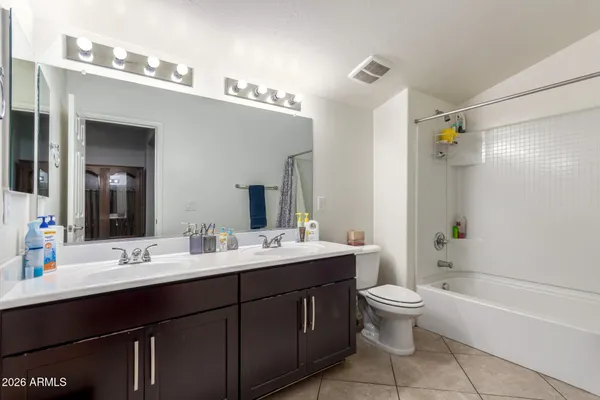 a bathroom with a double vanity sink toilet mirror and bathtub