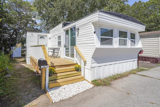 a view of a house with a small yard and wooden fence