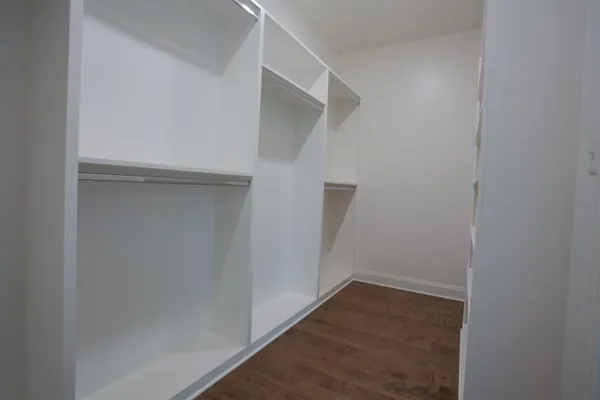 an empty room with a ceiling fan and a window
