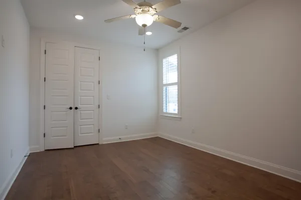 an empty room with a window and a fan