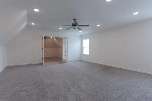 an empty room with windows and fan