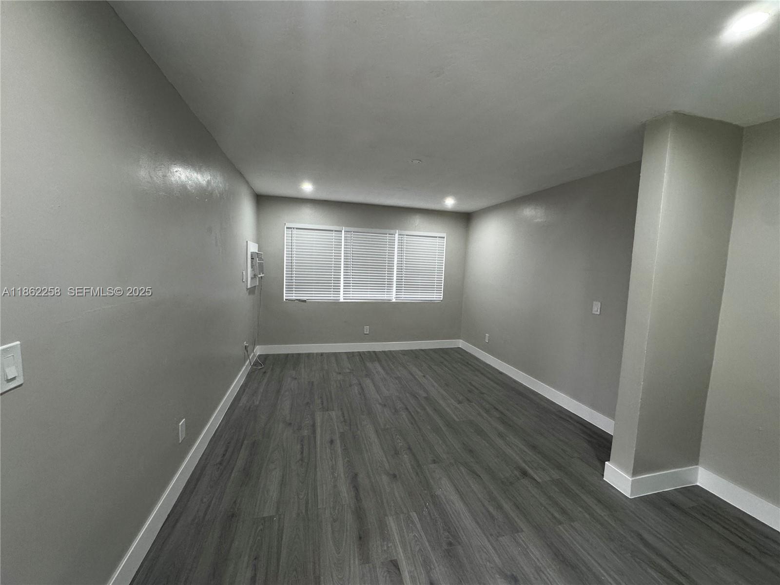 2377 Northwest 35th Street, Unit UTILITIES Miami, FL 33142 - Photo 5 of 9 an empty room with wooden floor and windows