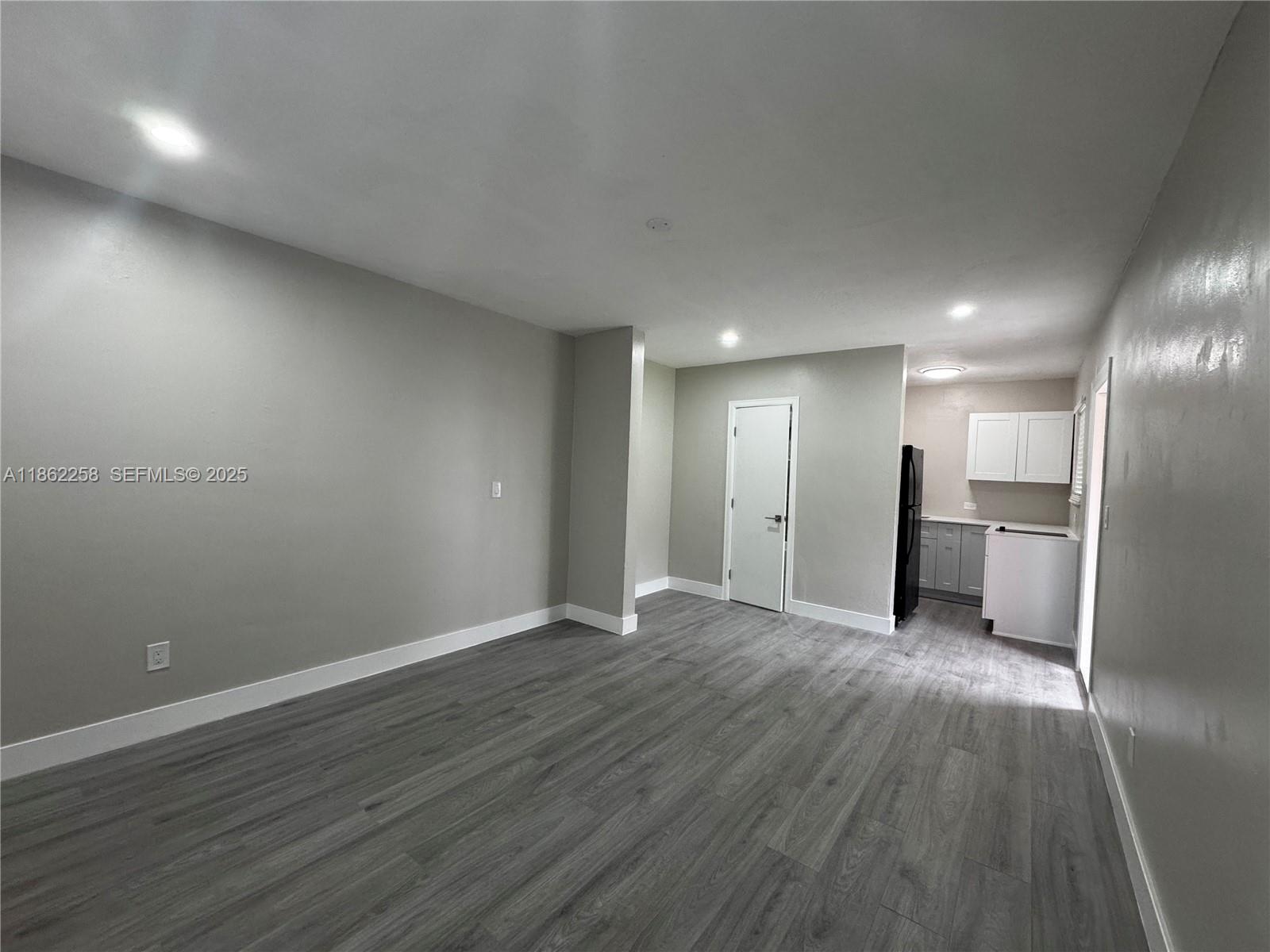 2377 Northwest 35th Street, Unit UTILITIES Miami, FL 33142 - Photo 6 of 9 a view of an empty room with wooden floor