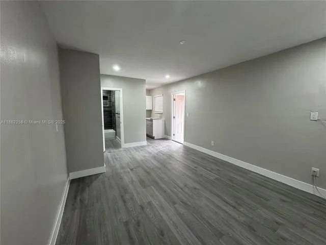 a view of empty room with wooden floor