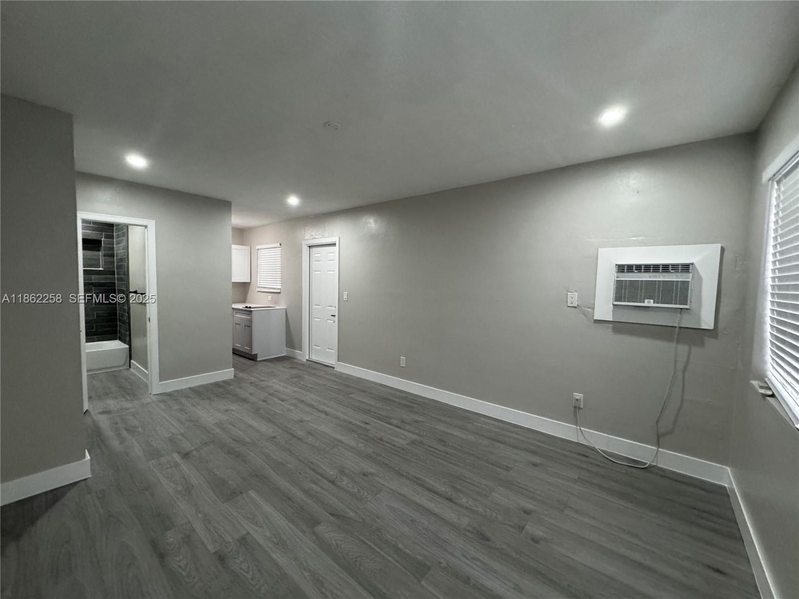 2377 Northwest 35th Street, Unit UTILITIES Miami, FL 33142 - Photo 9 of 9 an empty room with wooden floor and windows