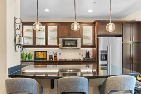a kitchen with stainless steel appliances granite countertop a sink window and refrigerator