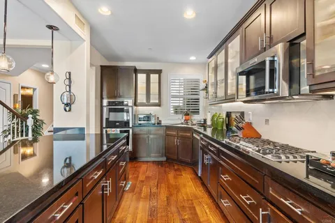 a kitchen with stainless steel appliances a sink stove and cabinets