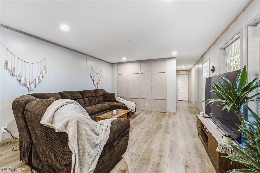 4516 Navarre Road Southwest, Unit 13 Canton, OH 44706 - Photo 5 of 30 Recessed lighting illuminates the wood-finish flooring and panel accent wall
