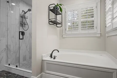 a bathroom with a bathtub and shower