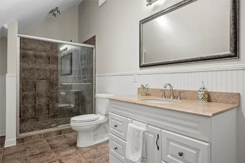 a bathroom with a granite countertop sink mirror and toilet