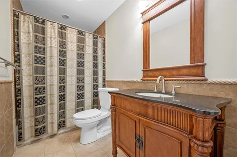 a bathroom with a granite countertop sink a toilet and a mirror