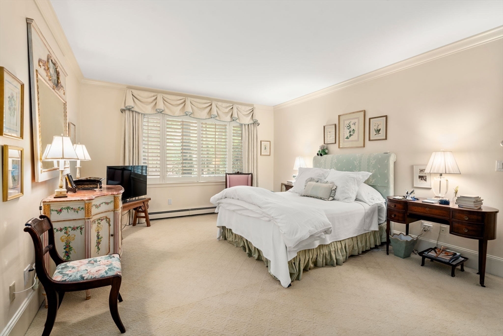 228 Allandale Road, Unit 1A Boston, MA 02467 - Photo 13 of 17 a spacious bedroom with a bed table chair and a window