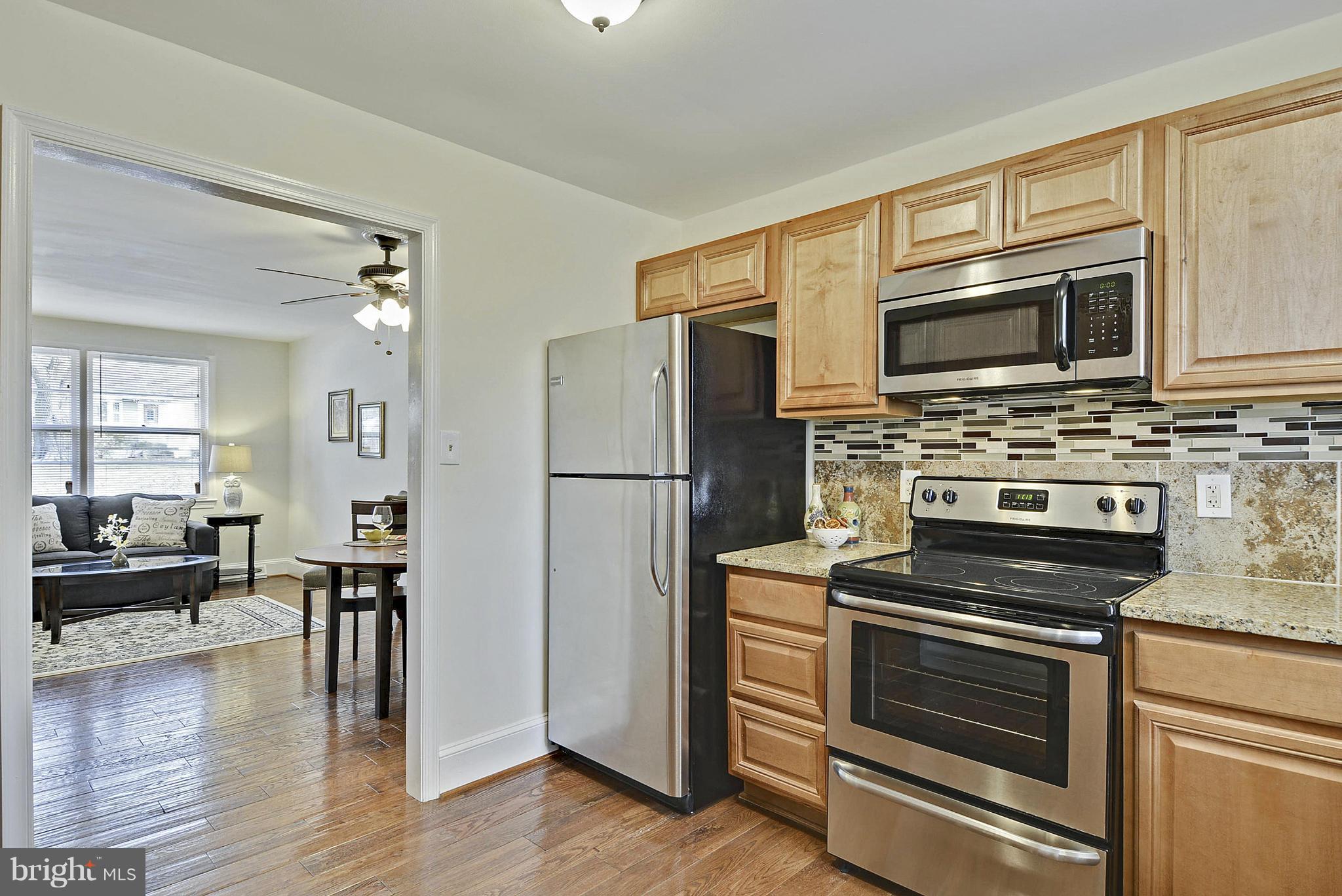 106 Harmony Hall Road Gaithersburg, MD 20877 - Photo 10 of 30 a kitchen with granite countertop a refrigerator and a stove top oven