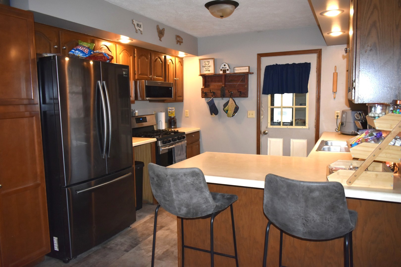 35 West 5th Street El Paso, IL 61738 - Photo 7 of 29 a kitchen with stainless steel appliances granite countertop a dining table chairs and a refrigerator