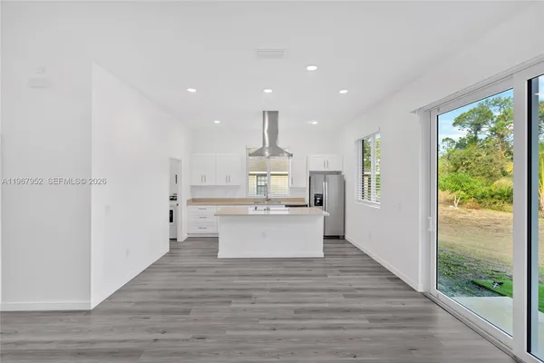 a view of kitchen with kitchen island sink and wooden floor