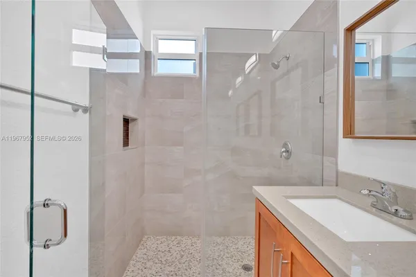 a bathroom with a sink a mirror and shower