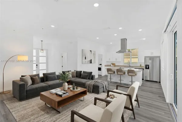 a living room with furniture kitchen and a table