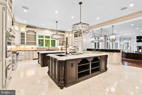 a large kitchen with a counter space a sink stainless steel appliances and cabinets