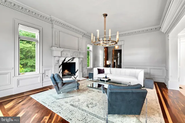 a living room with fireplace furniture and a chandelier