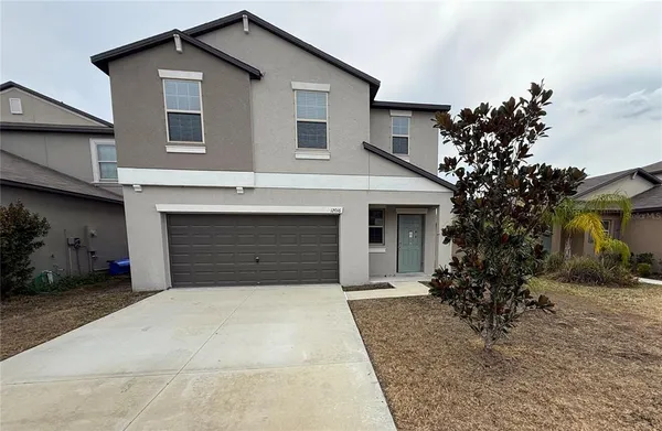 a front view of a house with a yard and garage