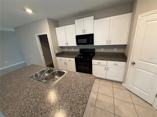 a kitchen with stainless steel appliances a sink a stove a microwave and cabinets