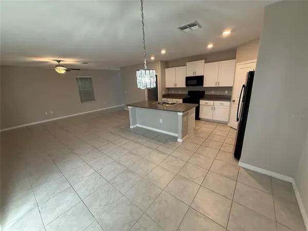 a large kitchen with kitchen island granite countertop a stove a sink and a refrigerator