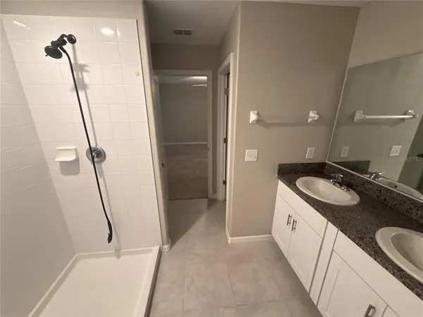 a bathroom with a granite countertop sink a toilet and shower