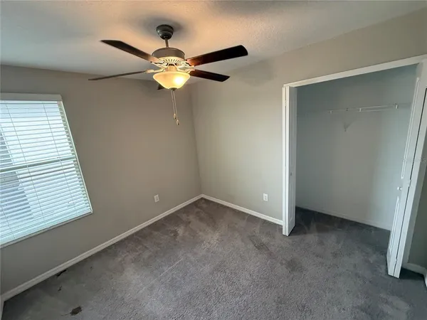 an empty room with a window and a fan