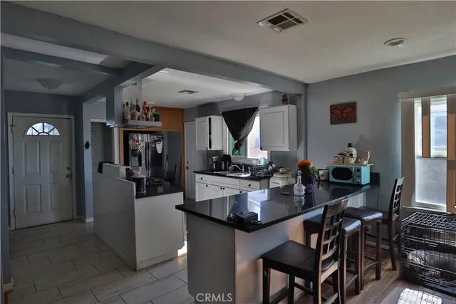 a kitchen island with granite countertop a refrigerator dining table and chairs