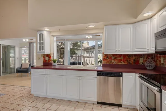 a kitchen with white cabinets and sink