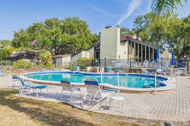 a view of backyard with swimming pool and patio