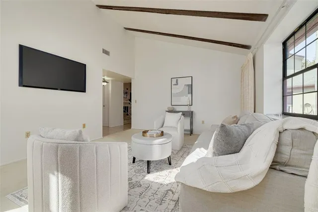 a living room with furniture a flat screen tv and a window