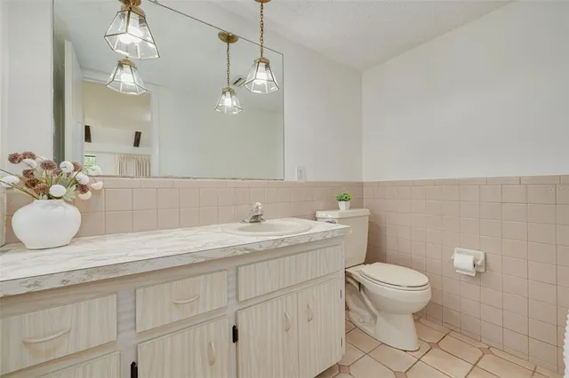 a bathroom with a granite countertop sink a toilet and a mirror