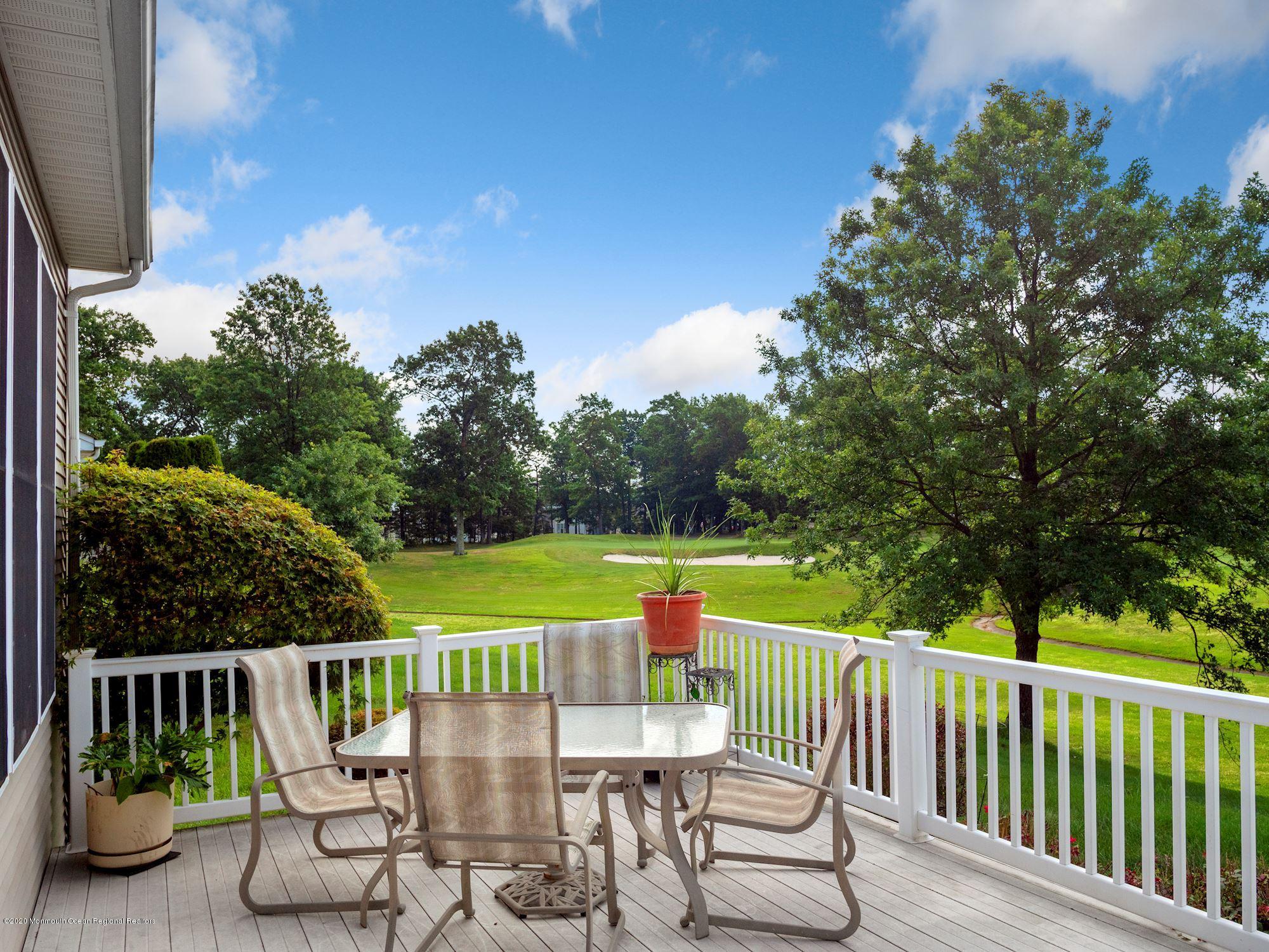 15 Winged Foot Road Jackson, NJ 08527 - Photo 12 of 34 a view of a deck with a table and chairs with wooden fence