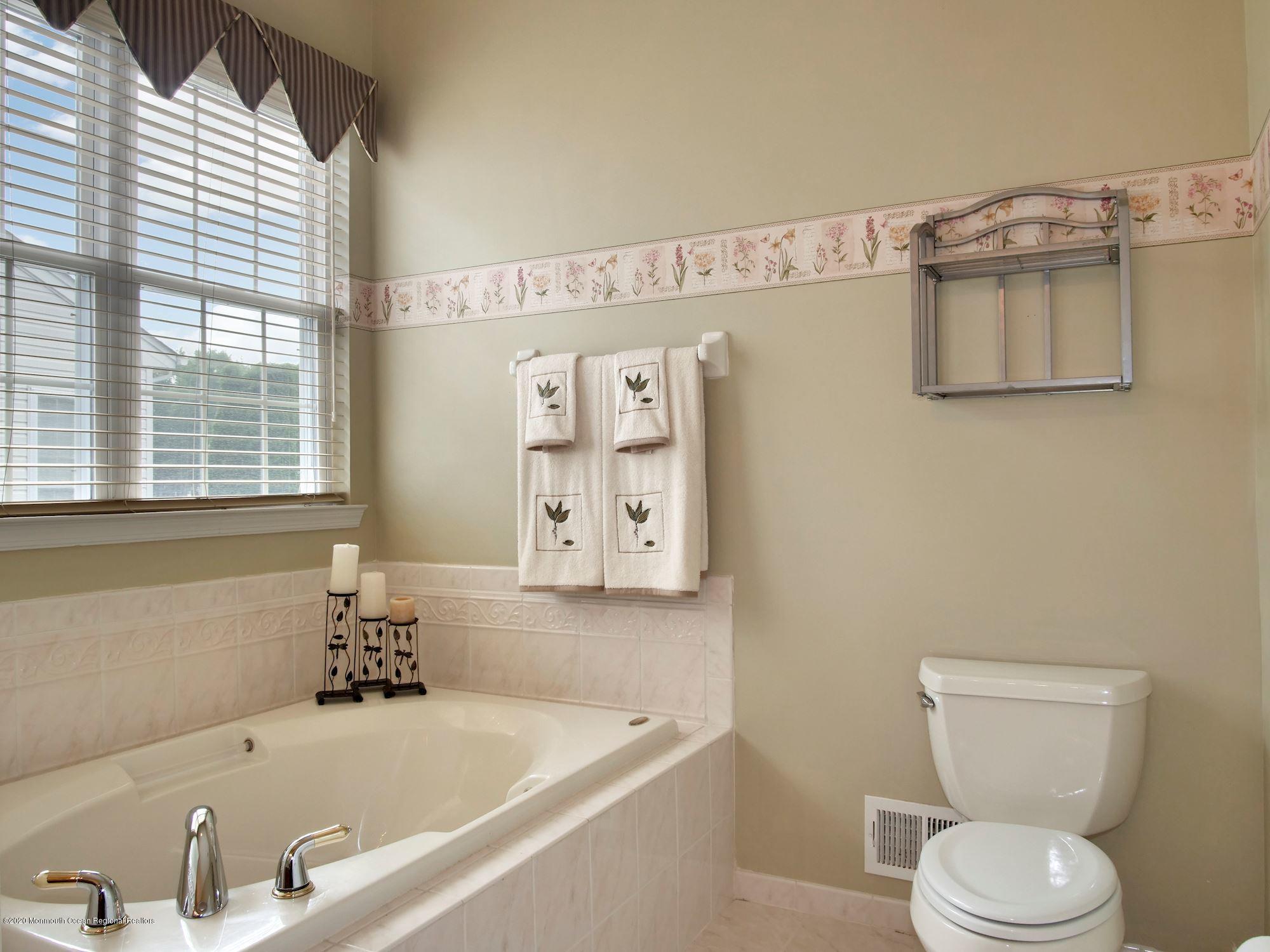 15 Winged Foot Road Jackson, NJ 08527 - Photo 26 of 34 a bath room with a toilet a sink and a bath tub