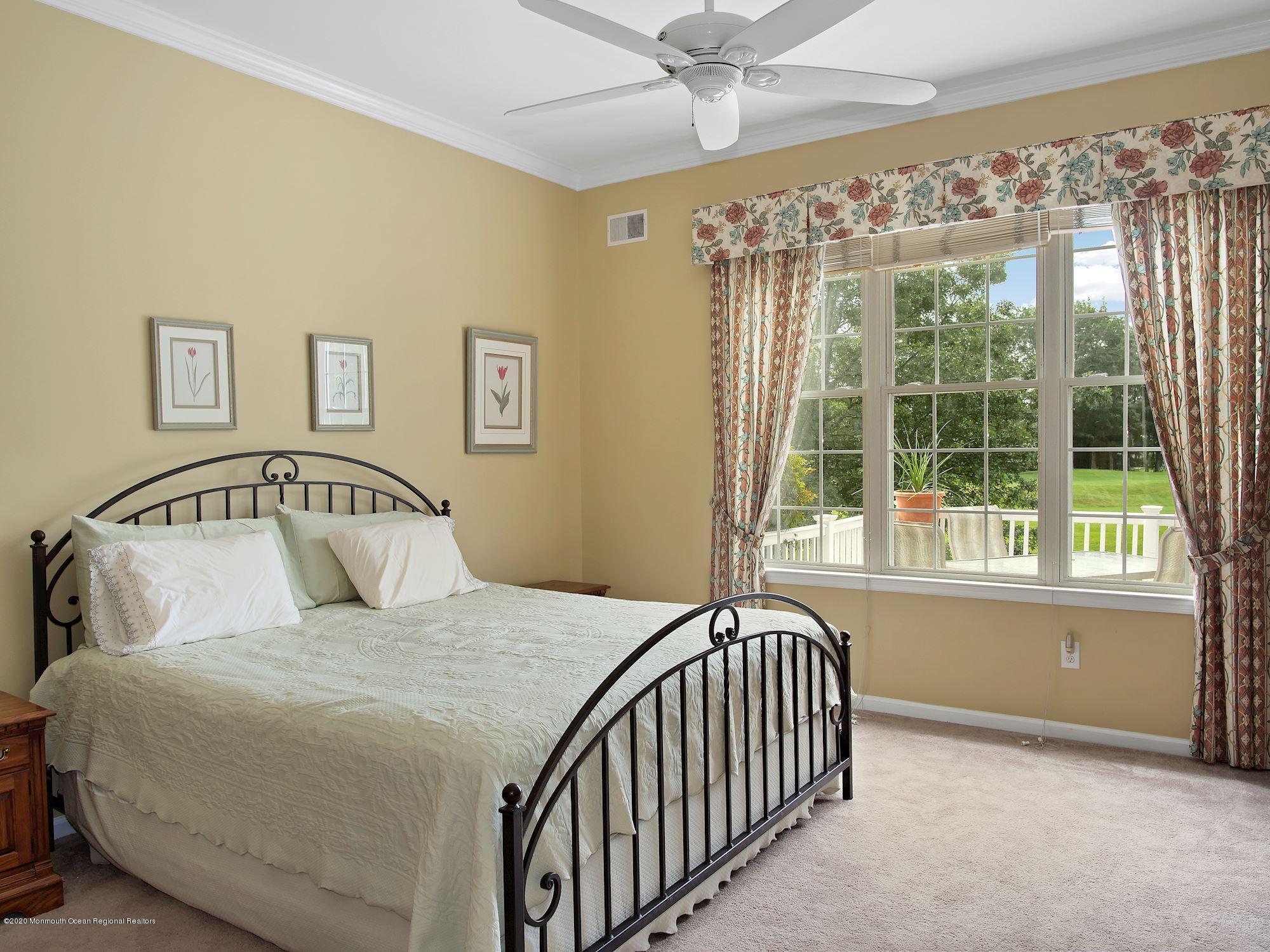 15 Winged Foot Road Jackson, NJ 08527 - Photo 27 of 34 a bedroom with a large bed and a chandelier