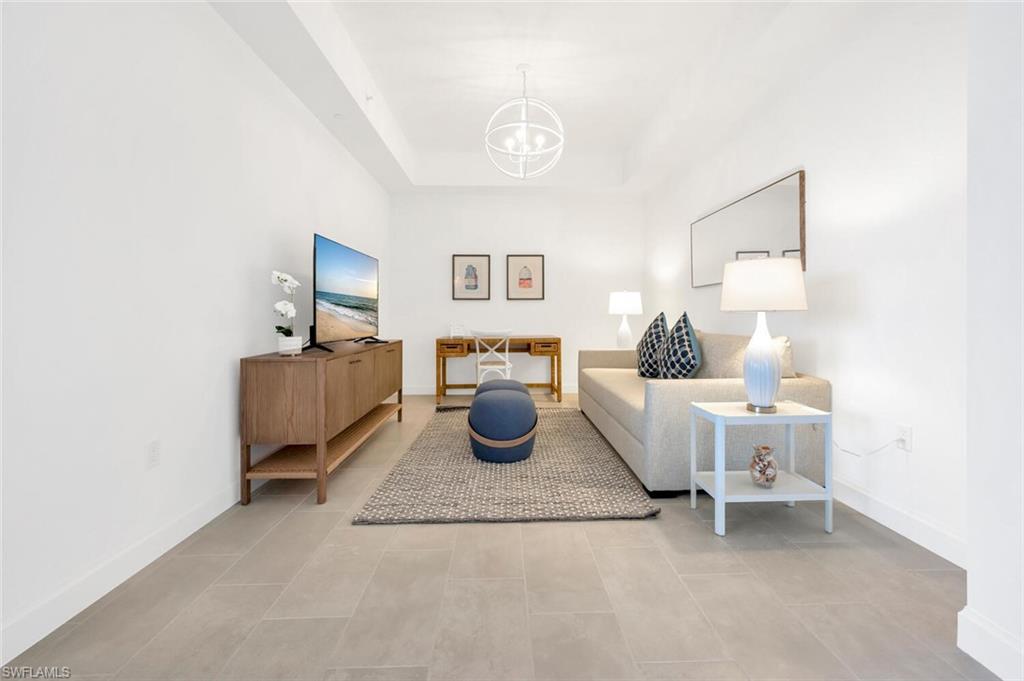 1125 Central Avenue, Unit 477 Naples, FL 34102 - Photo 15 of 48 a living room with furniture and a lamp