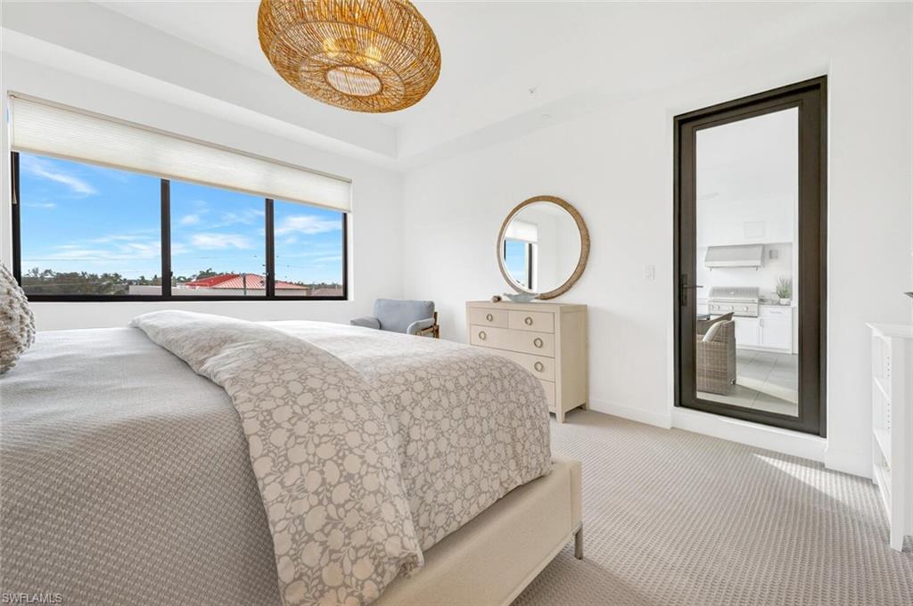 1125 Central Avenue, Unit 477 Naples, FL 34102 - Photo 18 of 48 a bedroom with a bed and a large mirror next to a window