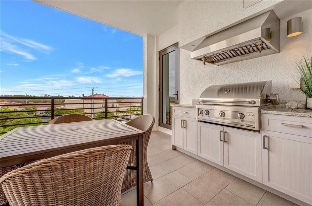 1125 Central Avenue, Unit 477 Naples, FL 34102 - Photo 31 of 48 a terrace with a table and chairs