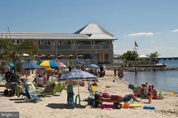a living room with furniture kitchen view and a wooden floor