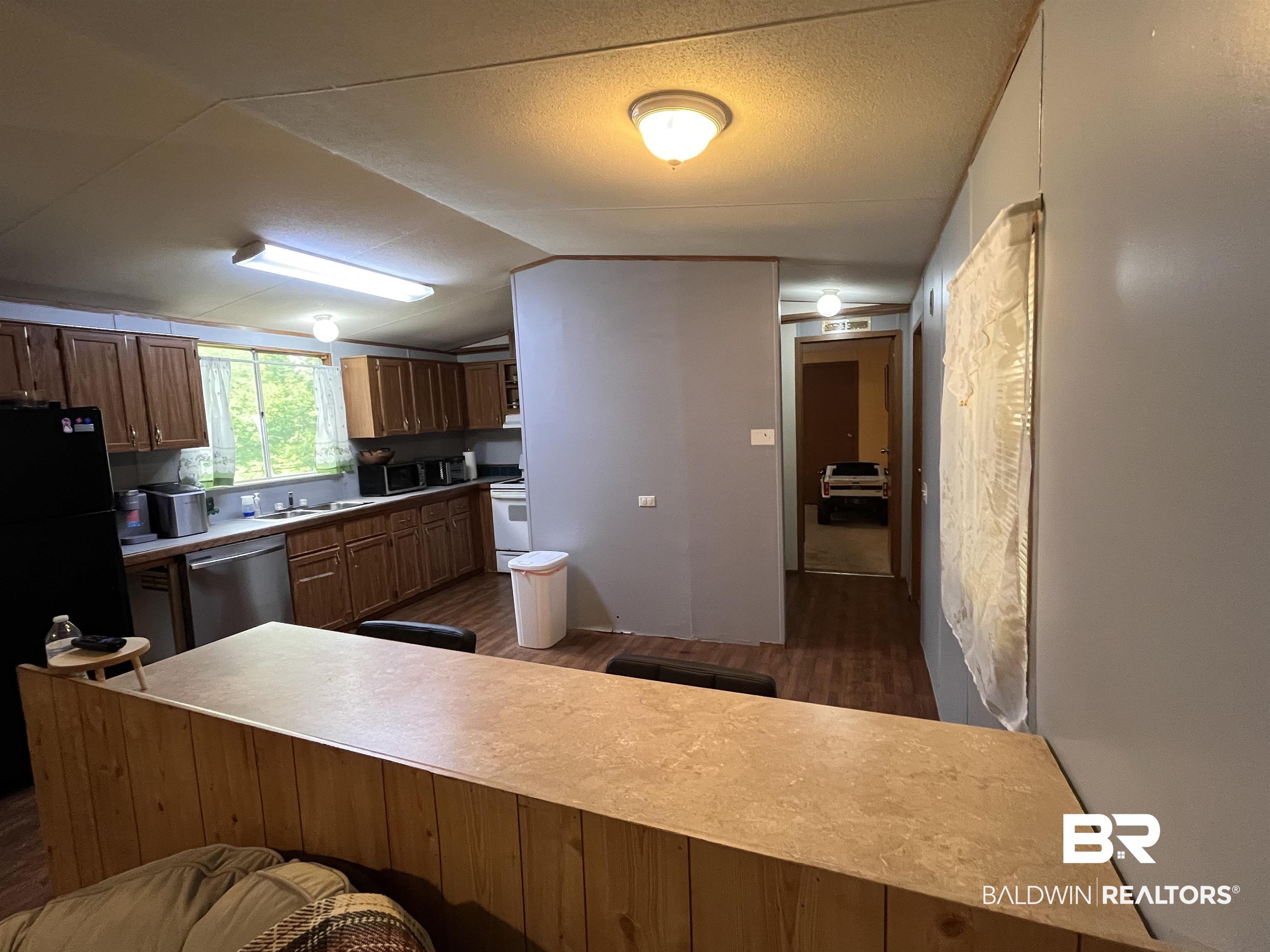 7719 Bermuda Drive Semmes, AL 36575 - Photo 4 of 10 Kitchen with refrigerator, wood finished floors, electric stove, and lofted ceiling