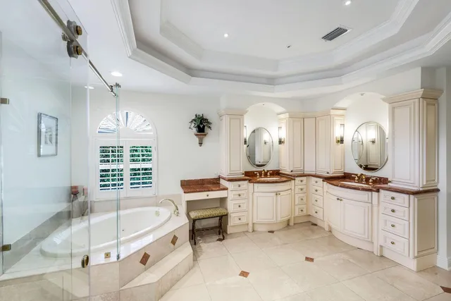 a large white kitchen with a stove a sink a window and dining table